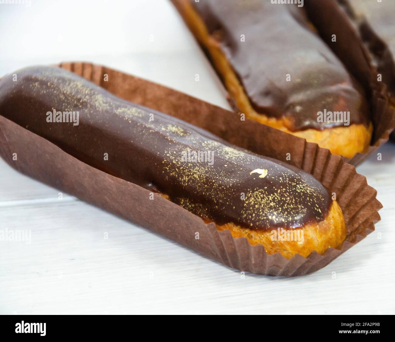 Gorgeous extra chocolate eclairs with gilded glaze Stock Photo