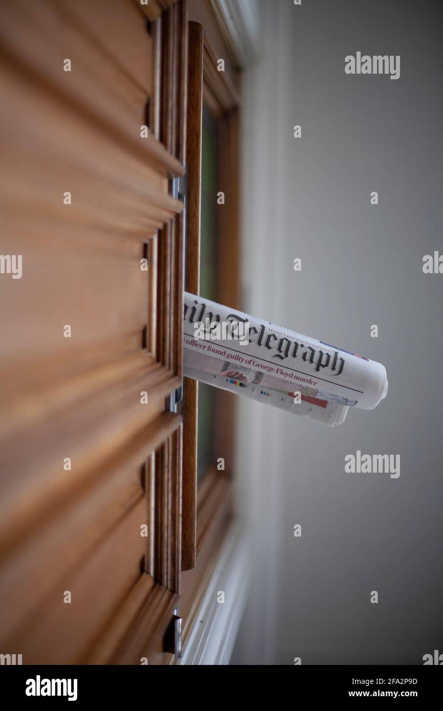 Daily newspaper in front door  letterbox Stock Photo