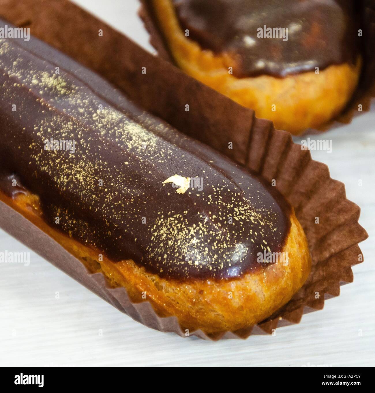 Gorgeous extra chocolate eclairs with gilded glaze Stock Photo
