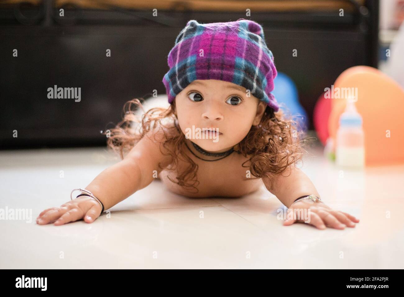 Closeup shot of a cute happy Indian female baby wearing a hat with fake hair  Stock Photo - Alamy
