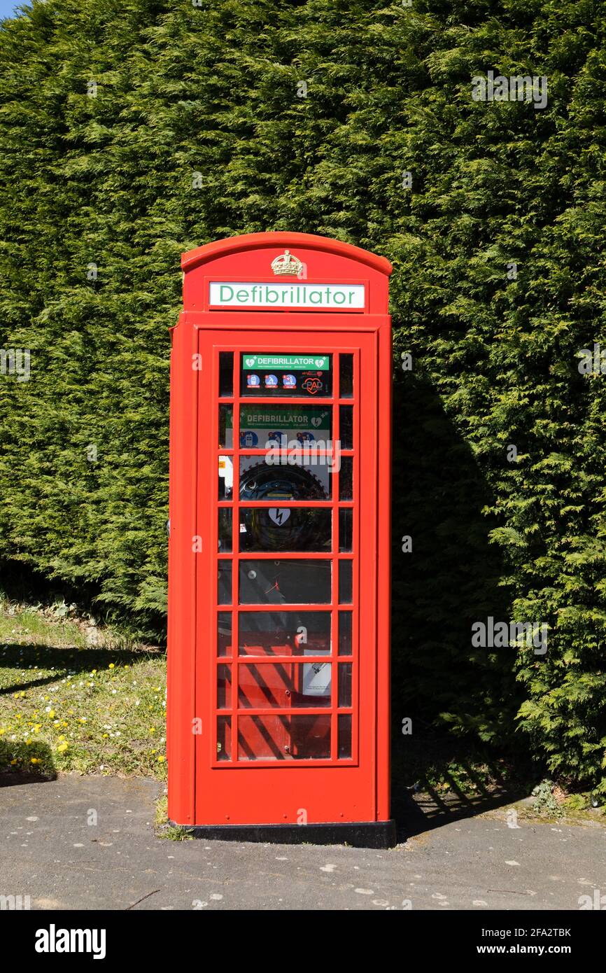 Traditional red British Phone box, now used to house a Defibrillator in Denton village. Lioncolnshire, England Stock Photo