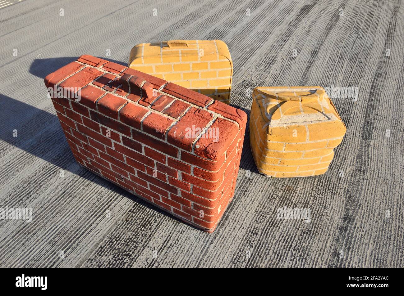 Unusual brick suitcases in the summer sun on a railway platform. Amsterdam. Stock Photo