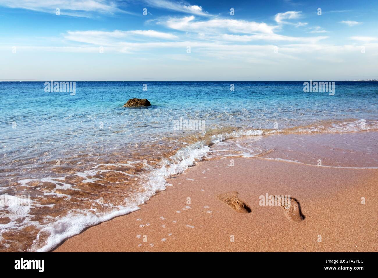 Tide waves on tropical beach sand and blue ocean Stock Photo