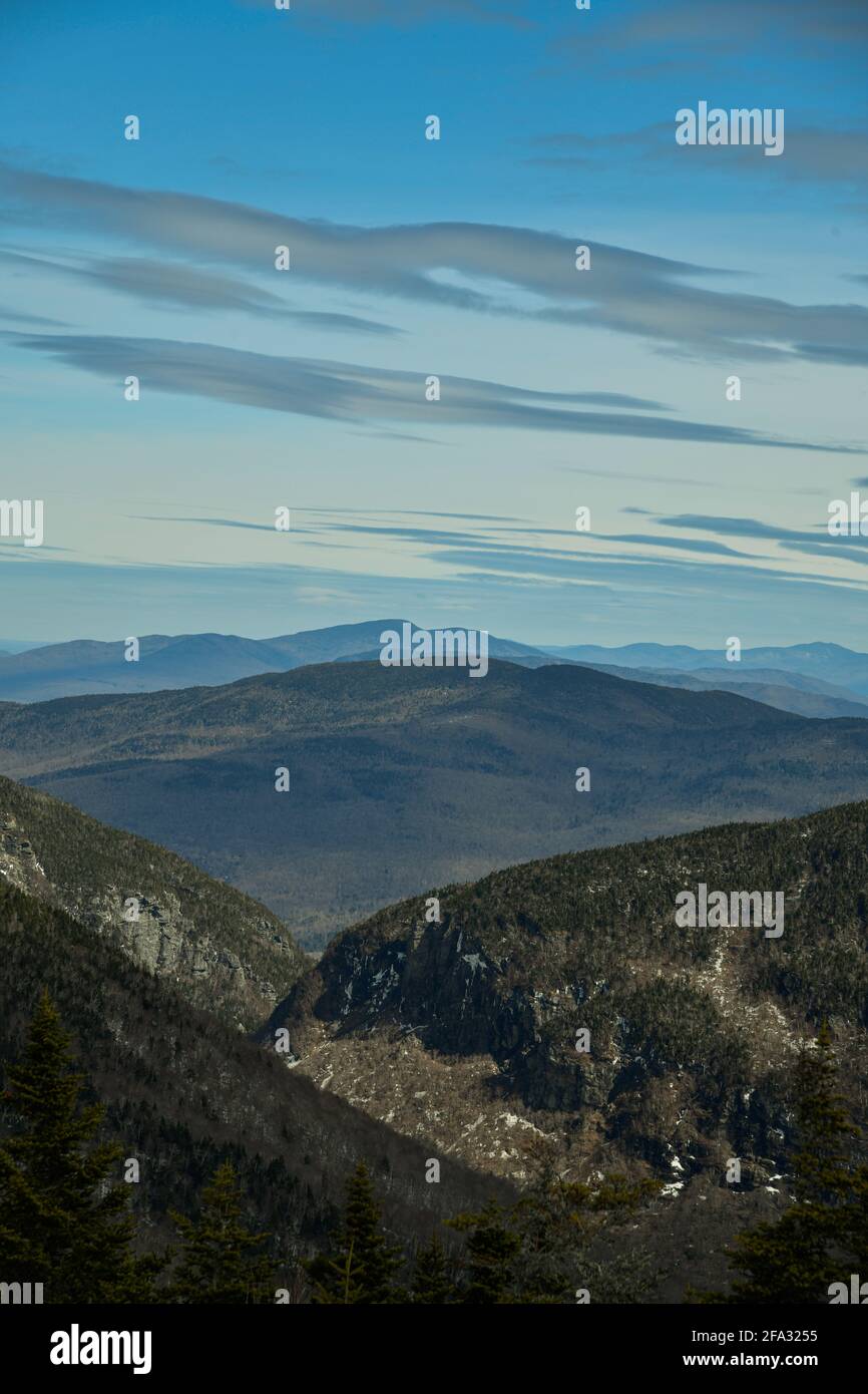 View from Mt. Mansfield Vermont at Stowe ski resort to Notch Path to Smugglers Notch. Late spring time with snow on the mountains and blue sky with cl Stock Photo