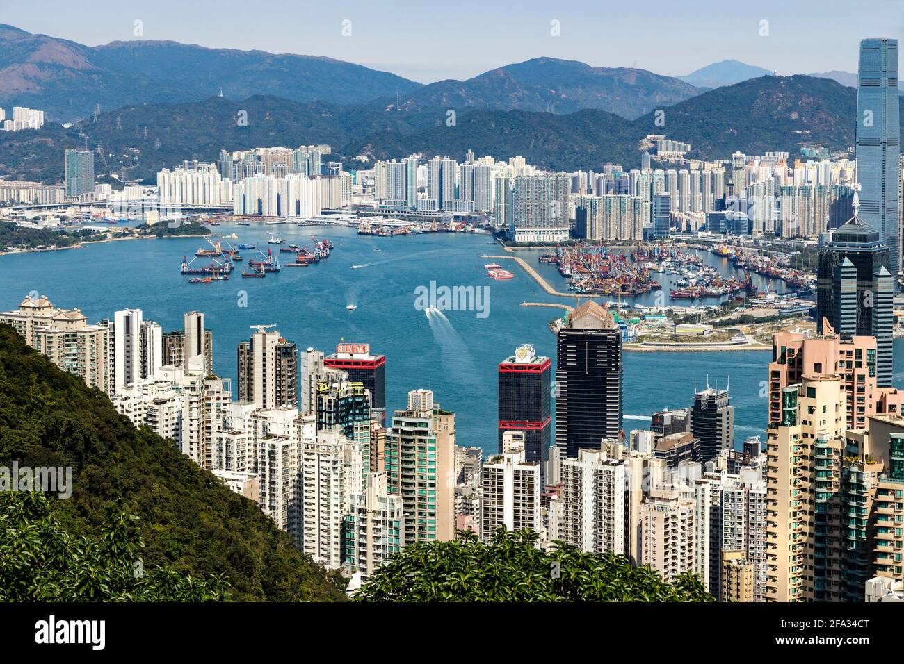 View across Hong Kong from Victoria Peak. Popular travel destination. Harbour and high-rise buildings dominate the skyline landscape. Stock Photo