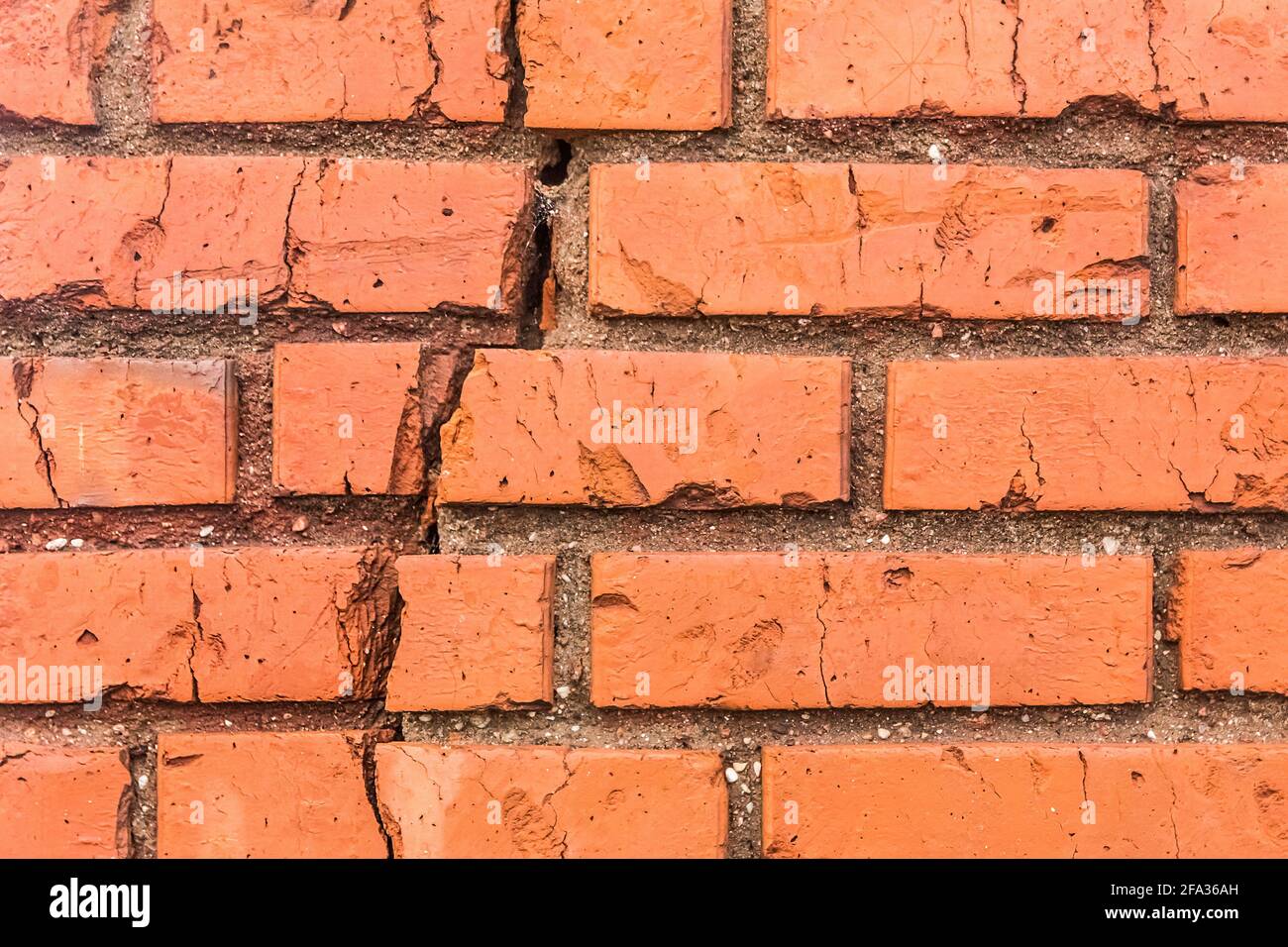 Crack on old brown damaged brick wall broken facade texture background. Stock Photo