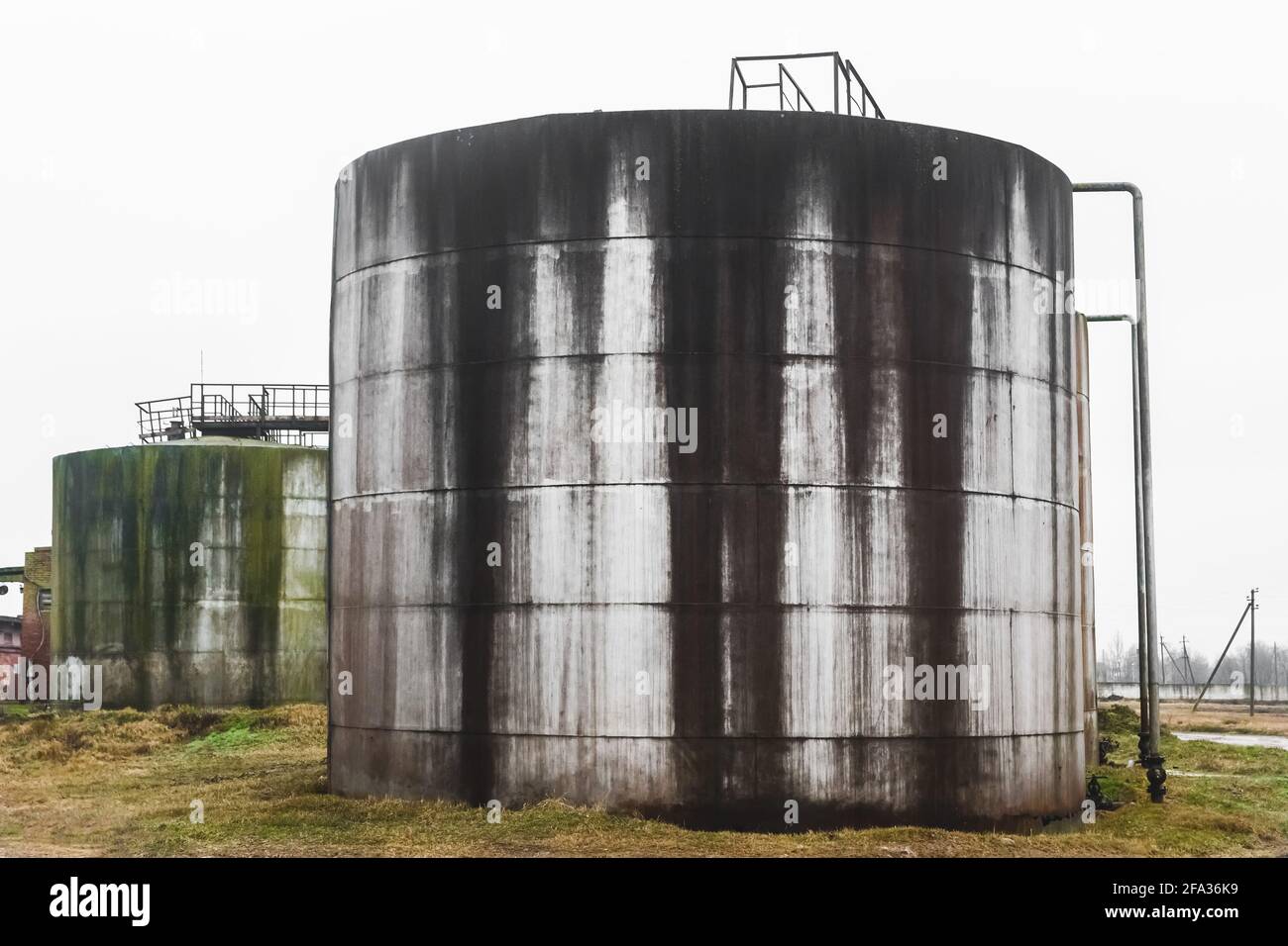 Old fuel oil tanks with smudges of fuel oil in an abandoned industrial