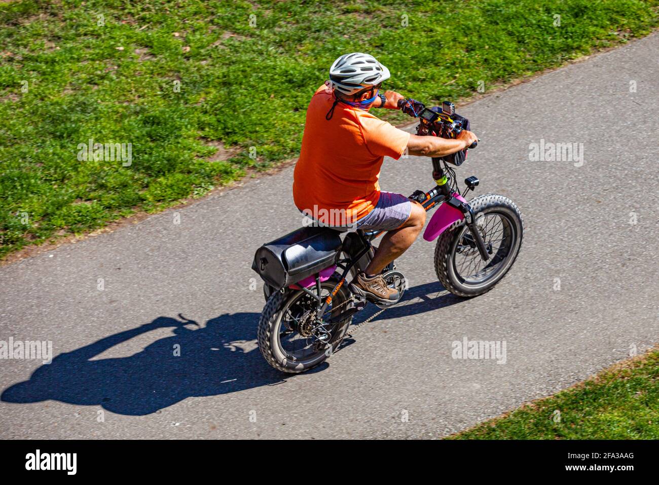 Man riding his fat-tyred electric-assist bicycle along a pathway in Steveston British Columbia Canada Stock Photo