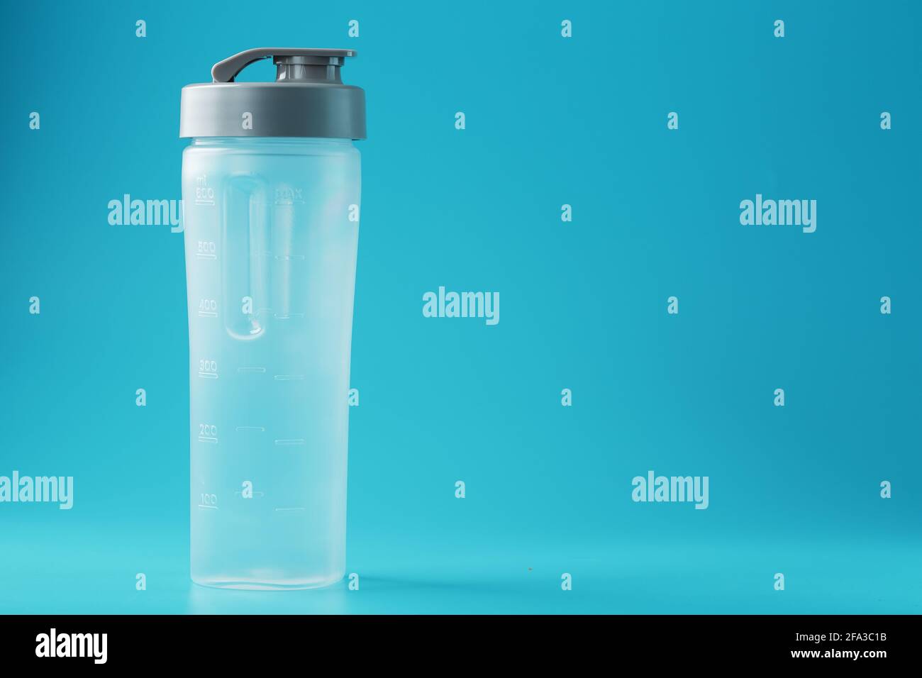 Shaker is an empty plastic smoothie cup on a blue background. Free space, minimalistic concept Stock Photo