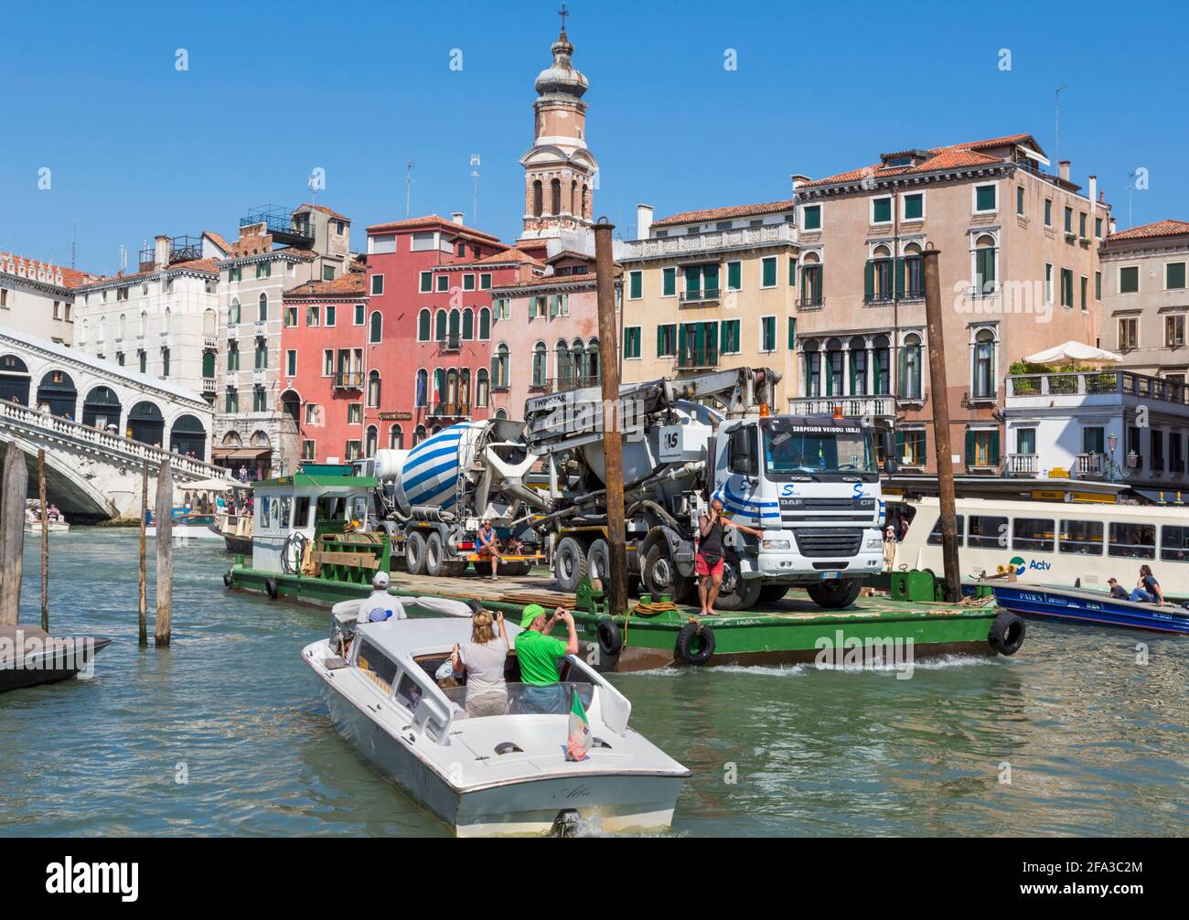 Venice, Venice Province, Veneto Region, Italy.  Every day traffic on the Grand Canal.   Here, two trucks are being transported on a barge.  Venice and Stock Photo