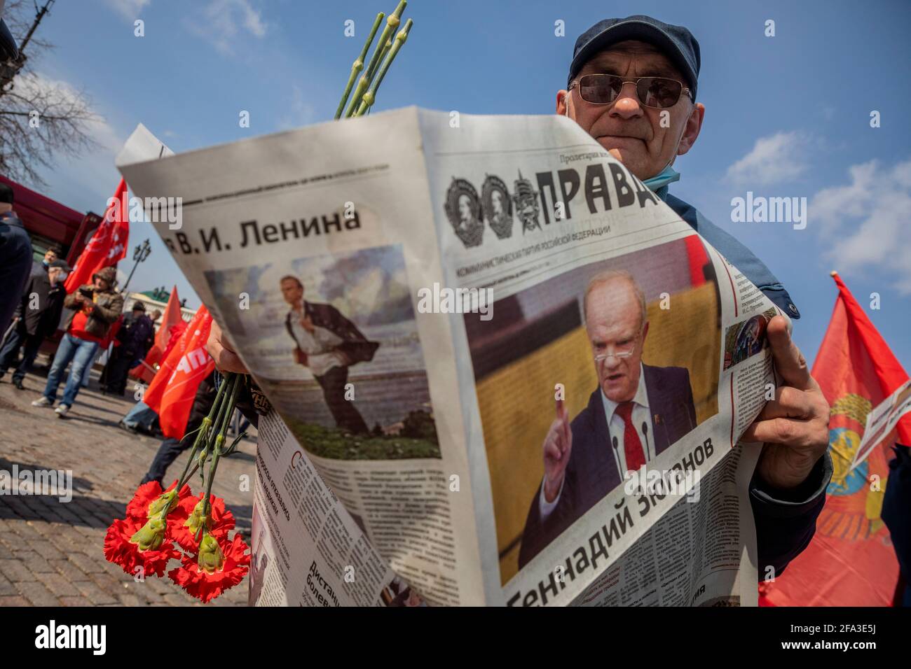 Moscow, Russia. 22nd of April, 2021 Communist supporter reads 'Pravda' (Eng: Truth) newspaper at Manegnaya square in central Moscow before visit the Mausoleum of the Soviet founder Vladimir Lenin to mark the 151st anniversary of his birth, Russia. On the front page of the newspaper is a portrait of the Communist Party leader Gennady Zyuganov. The Pravda is Russian broadsheet newspaper, formerly the official newspaper of the Communist Party of the Soviet Union, when it was one of the most influential papers in the country with a circulation of 11 million Stock Photo