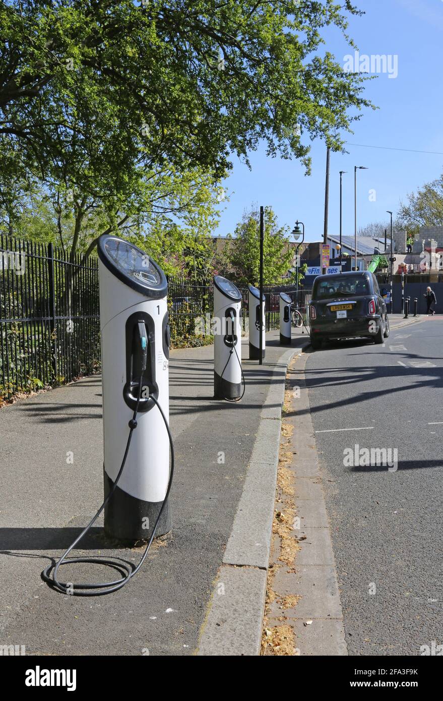 Kerbside electric vehicle charging points on Elmwood Rd in Dulwich, London, UK. Shows new LEVC TX plug-in hybrid electric taxi connected and charging. Stock Photo