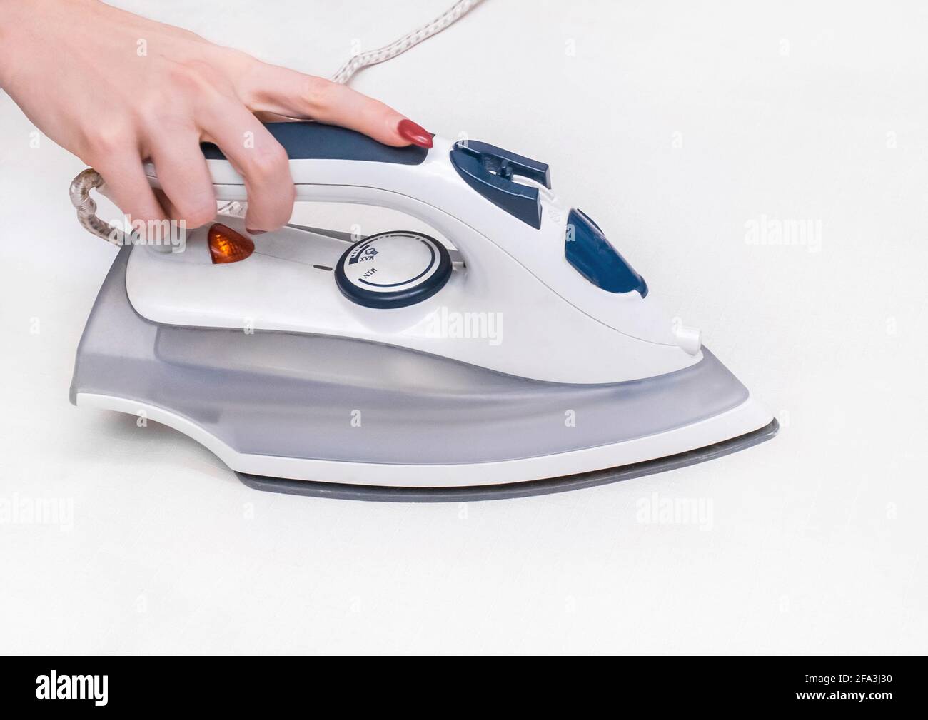 Girl's hand ironing a white tablecloth background Stock Photo Alamy