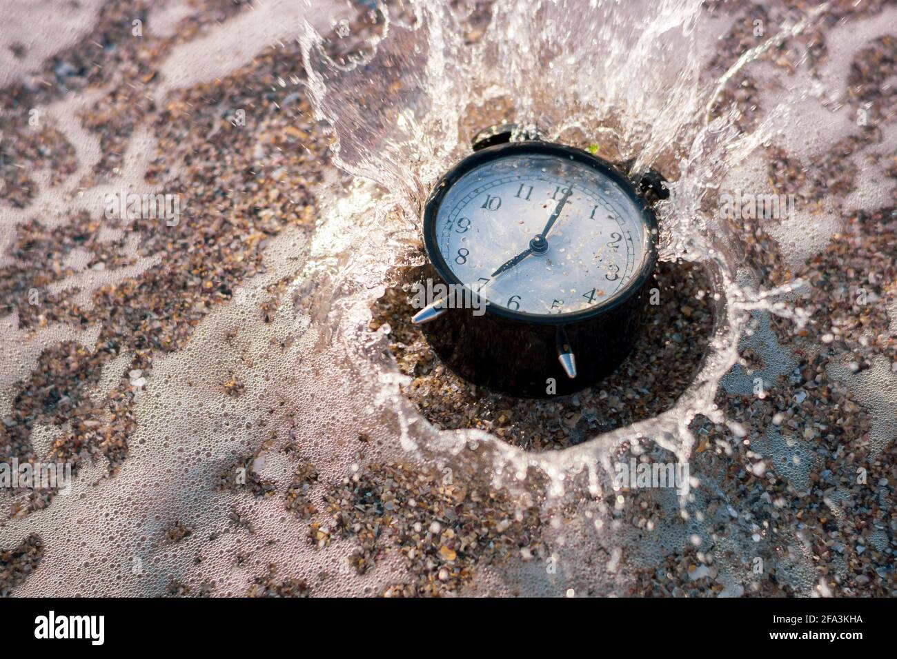 Alarm clock splashing in the beach water Stock Photo Alamy