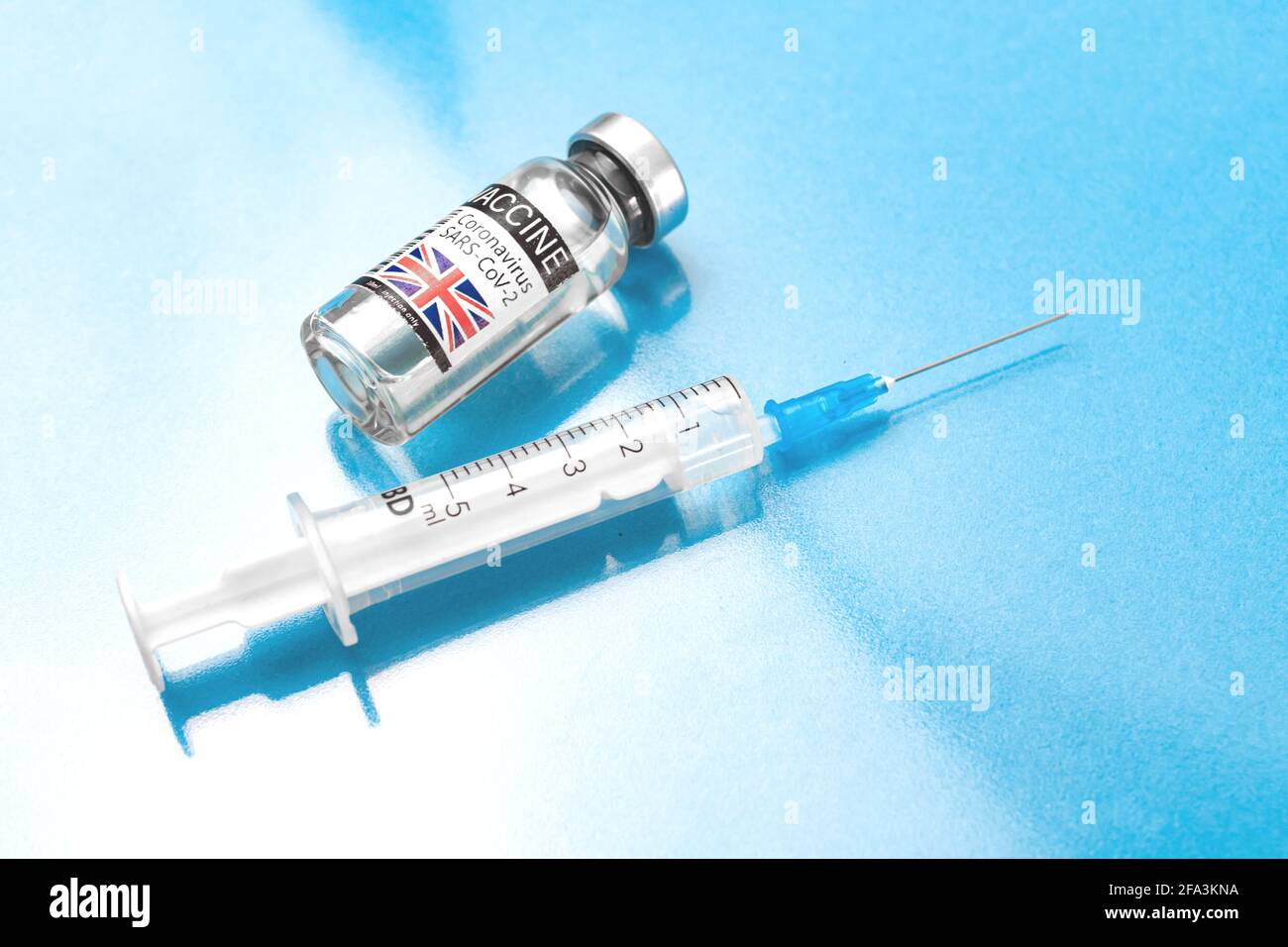 United Kingdom UK coronavirus COVID-19 vaccince vial with syringe, vaccination in Europe concept, blue glass background, laboratory photo Stock Photo