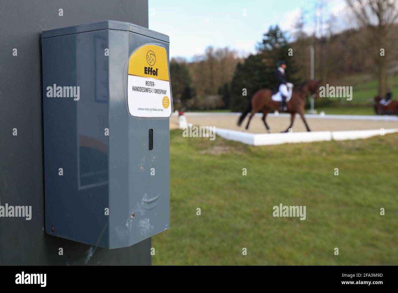 Hagen Am Teutoburger Wald, Germany. 22nd Apr, 2021. Rider hand disinfectant spray to combat coronavirus is available to dressage riders at a warm-up area before a dressage test at the Horses & Dreams International Horse Show. Credit: Friso Gentsch/dpa/Alamy Live News Stock Photo