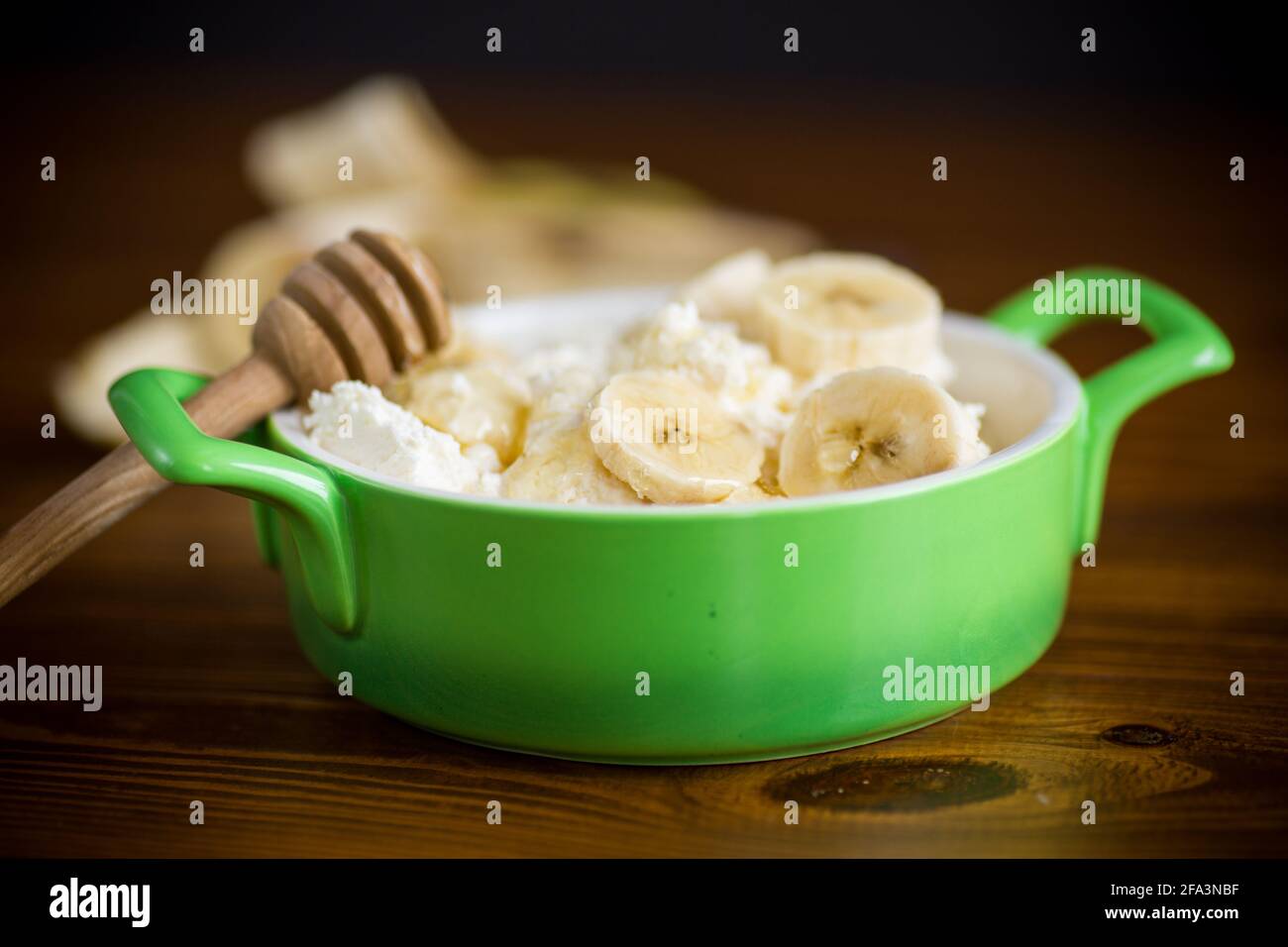 homemade cottage cheese in a bowl with bananas and honey Stock Photo