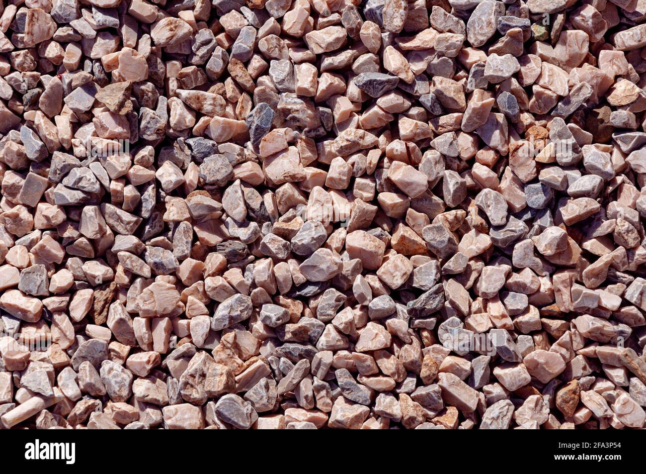 Sharp granite rocks background in a sunny day. Fine gravel rocks. Pieces crushed gravel for the construction industry Stock Photo