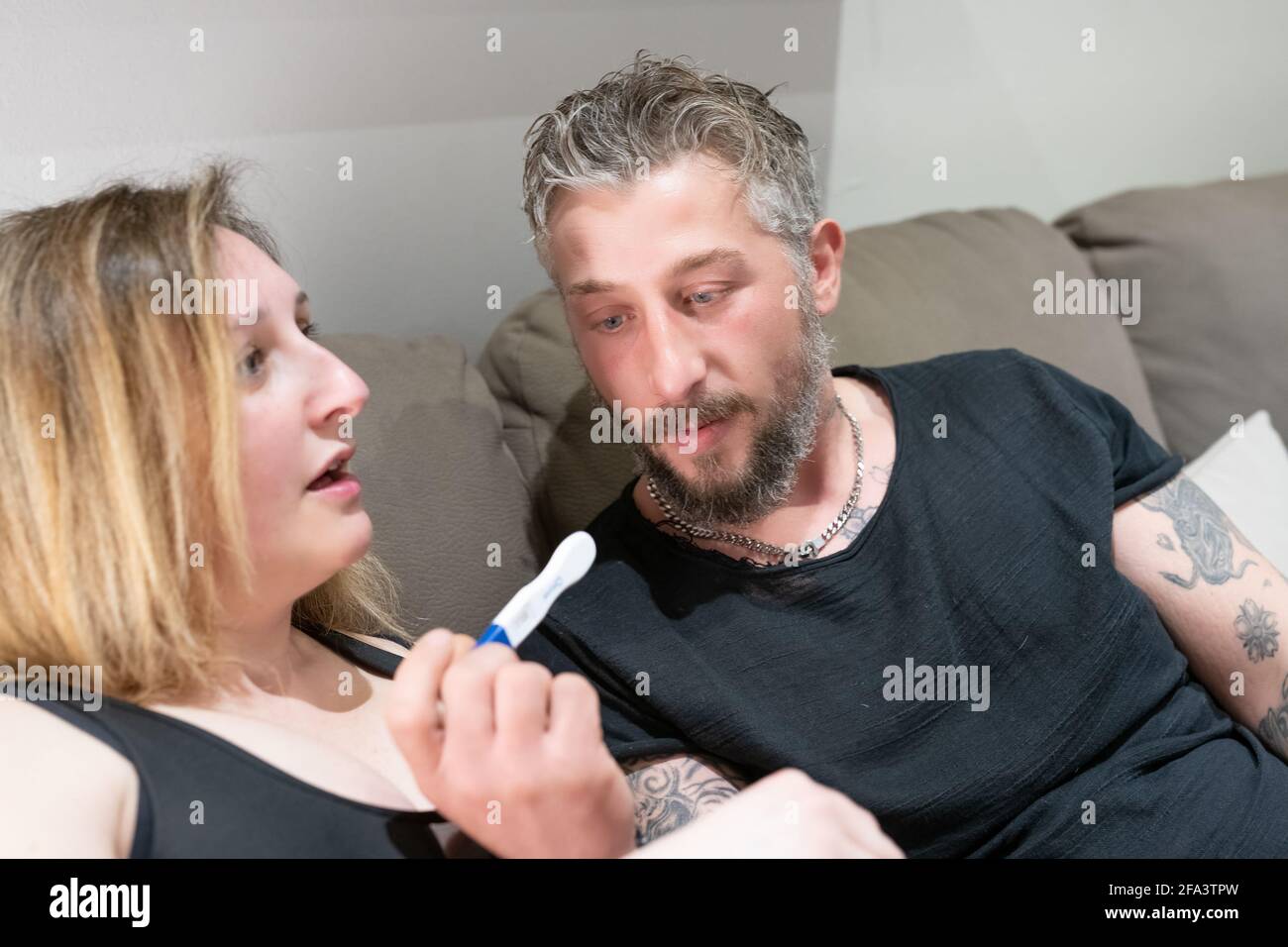 Excited married couple discovering result of pregnancy test. Surprised man face expression. Stock Photo