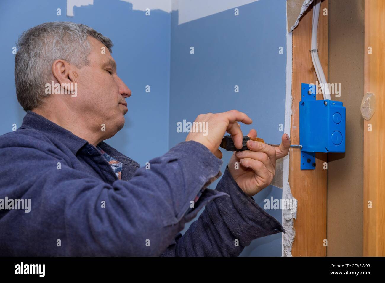 Electrician fasten the electrical box to the beams to place Stock Photo ...