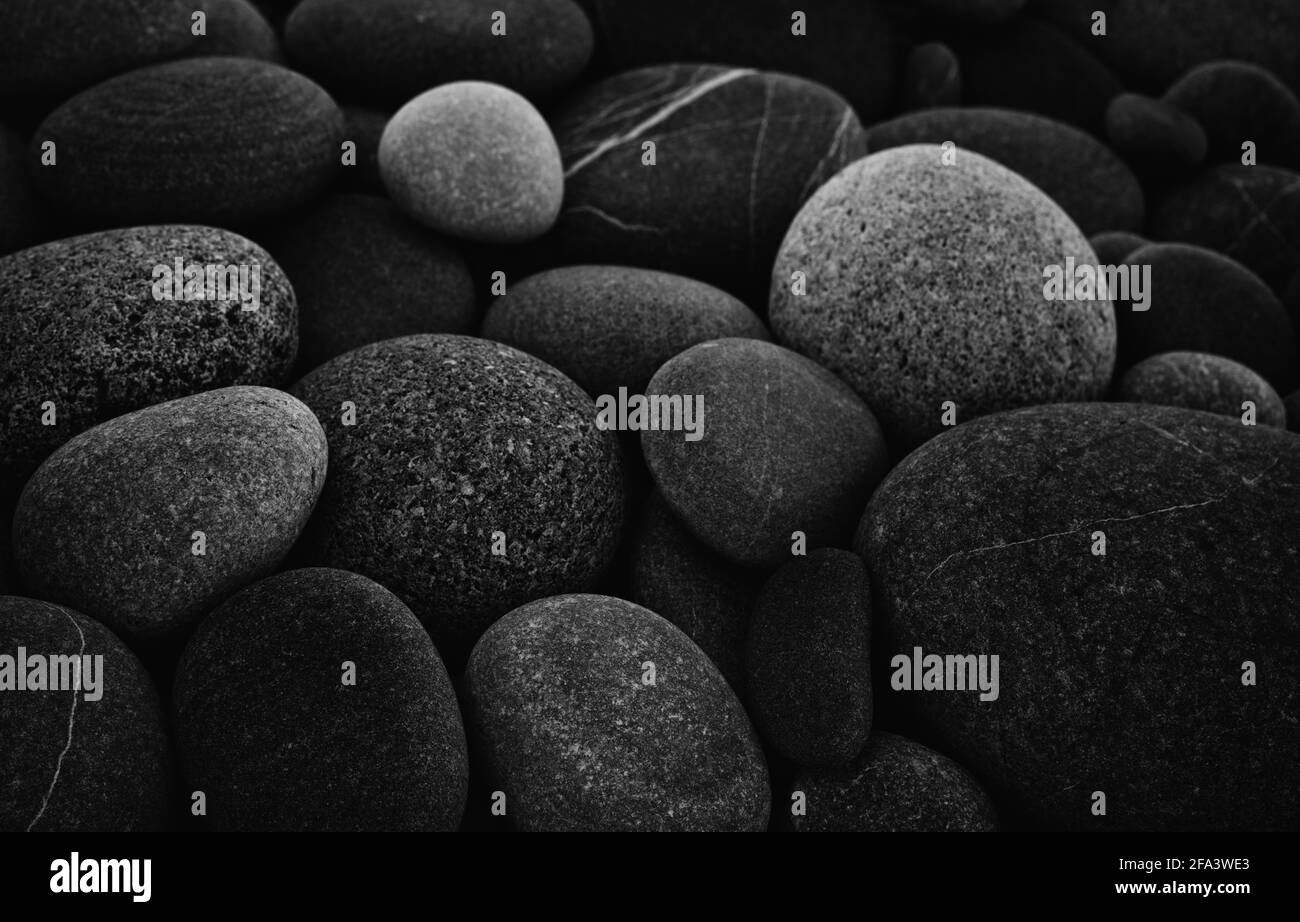 Dark black abstract smooth round pebbles sea texture background Stock Photo