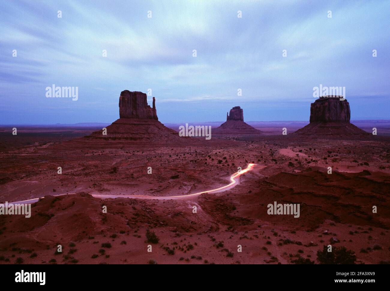 USA, Arizona, Monument Valley,  time exposure of car trails on road leading to Left and Right Mittens, Stock Photo