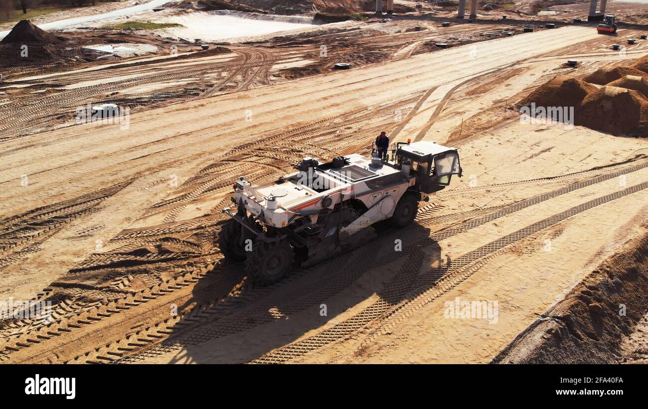 Warsaw, Poland 04.10.2019 - Heavy machinery preparing soil foundation of multilane road. Aerial view from drone on road construction site  Stock Photo