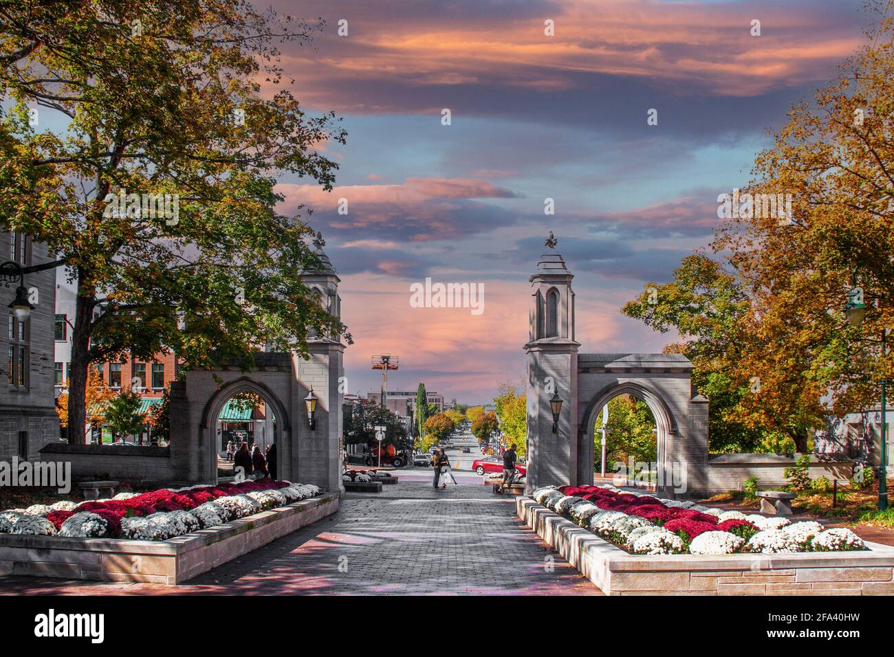 Overlooking Bloomington Indiana from University entrance on fall day at sunset with flowers and a view of the main street and unidentifiable people Stock Photo