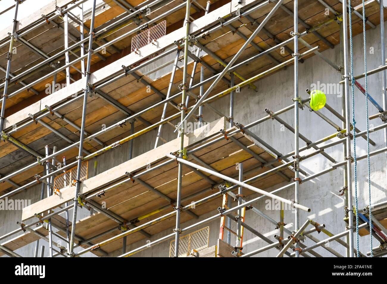 Single safety helmet hanging on the end of a scaffolding pole on a