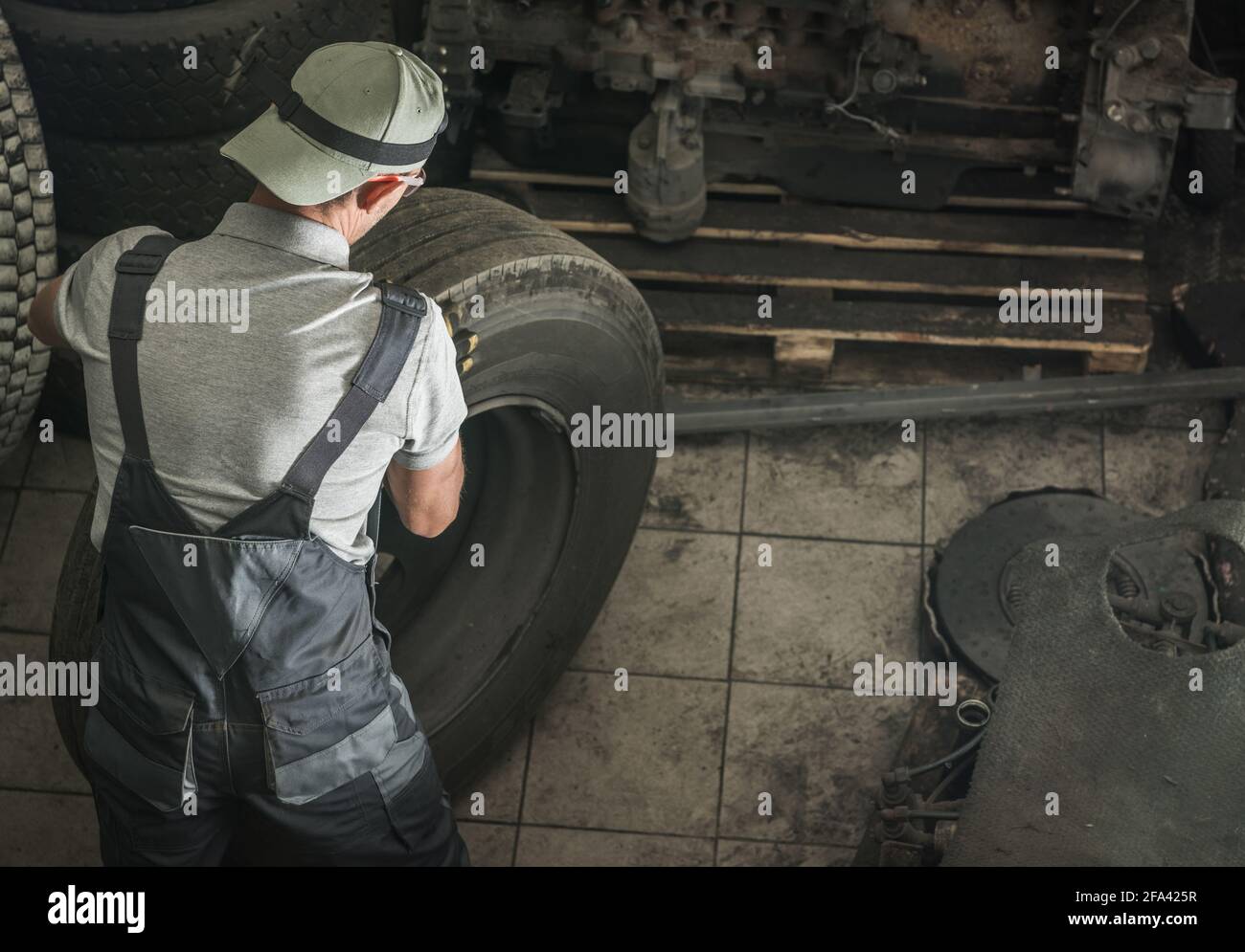 Caucasian Automotive Worker in His 40s Replacing Heavy Duty Truck Wheel For the New One. Semi Truck Service. Stock Photo
