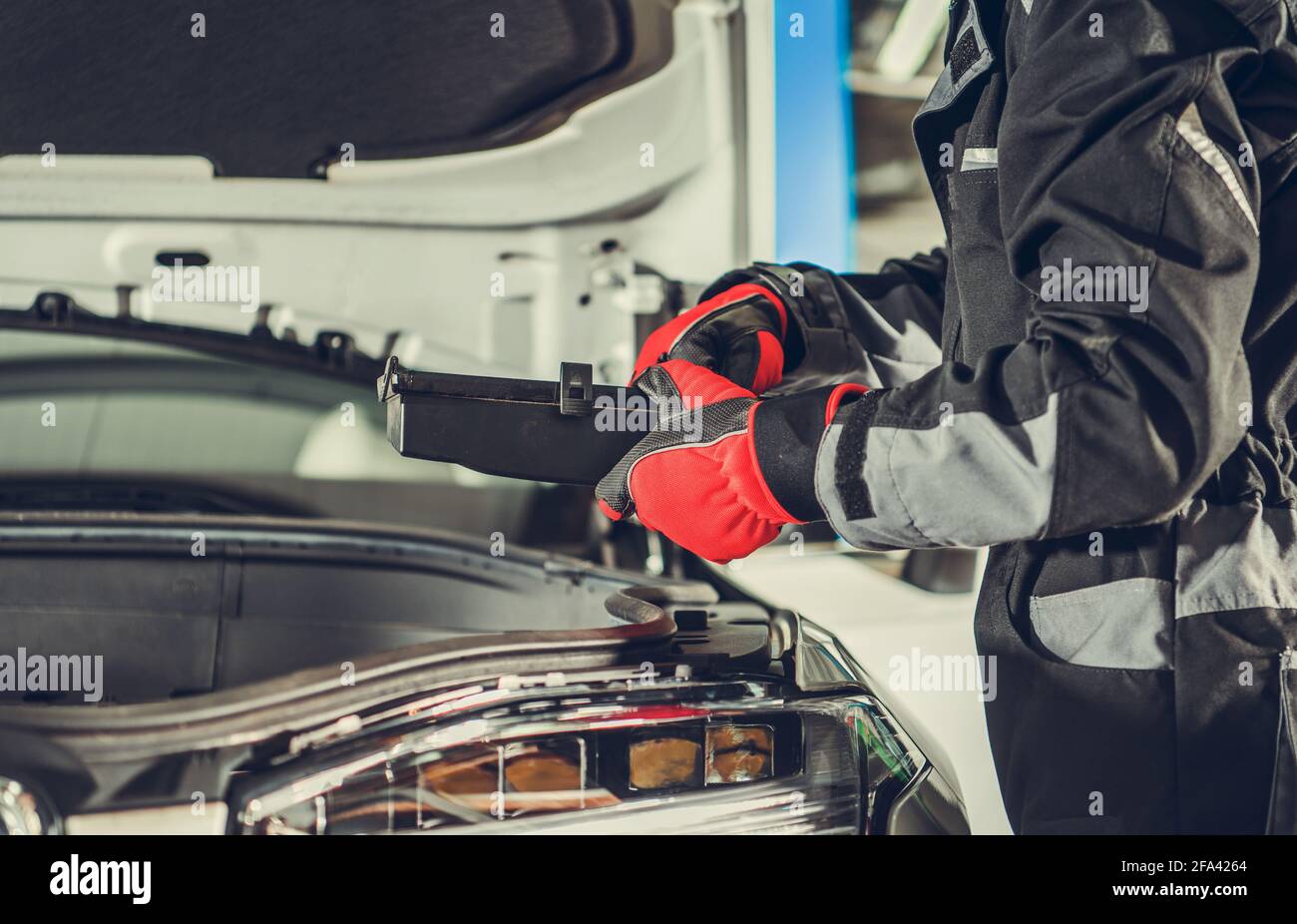 Professional Car Mechanic Looking For Burned Fuse Under Vehicle Hood. Automotive Industry Theme. Stock Photo