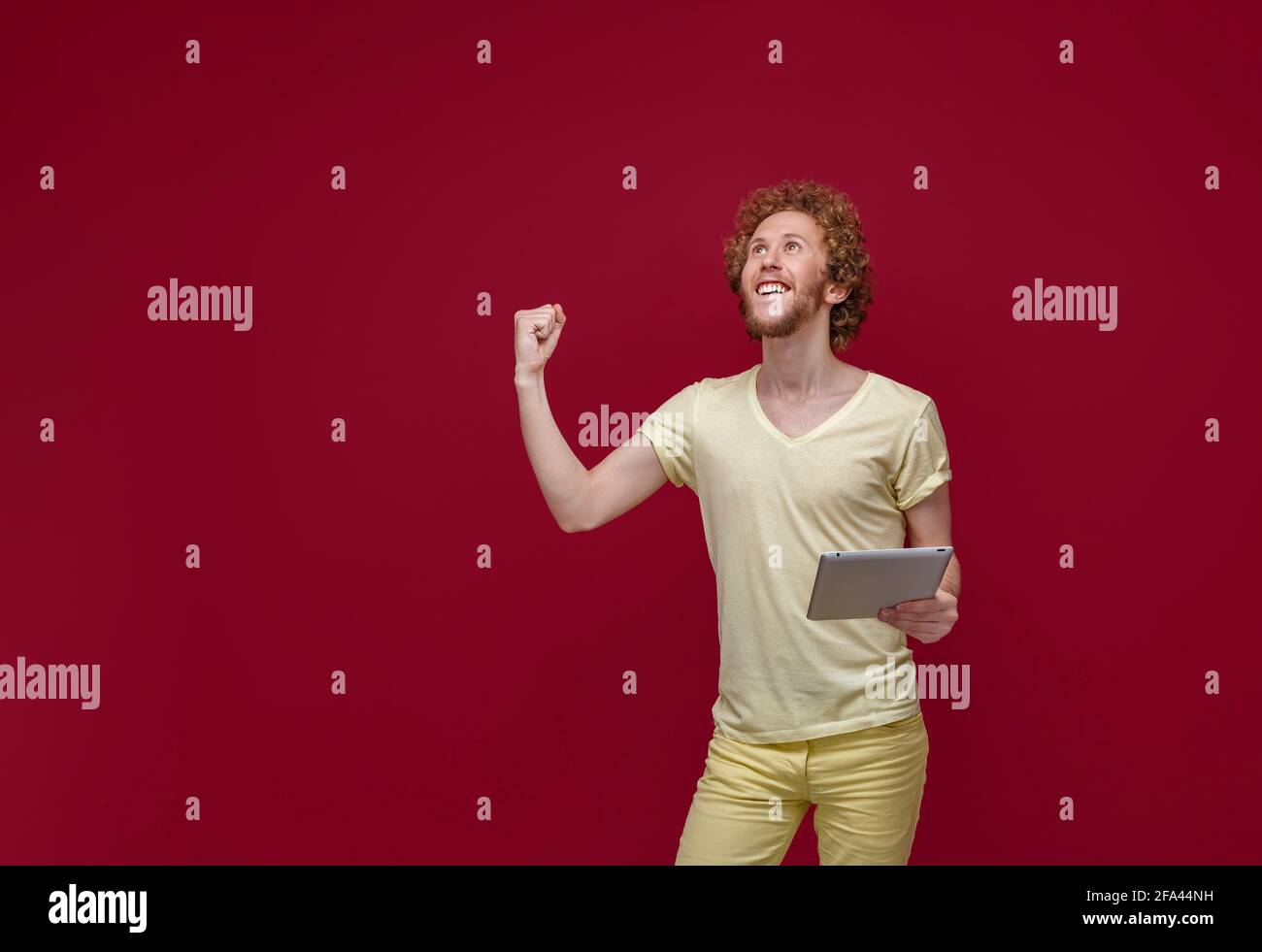 Young curly-haired man with tablet Stock Photo