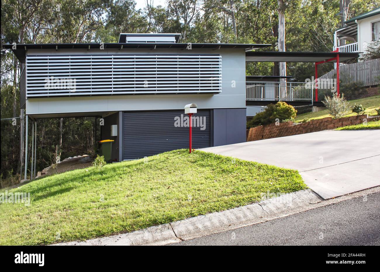 Very modern Australian House with outside wooden blinds on the side of a hill Stock Photo