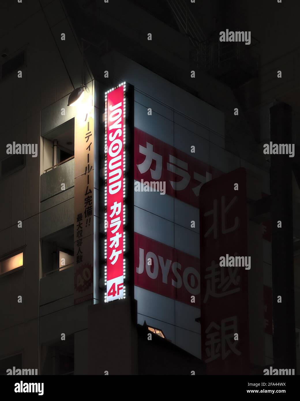 Niigata, Japan - October 23 2020: Night view of a large illuminated Joysound sign, a Japanese karaoke chain Stock Photo