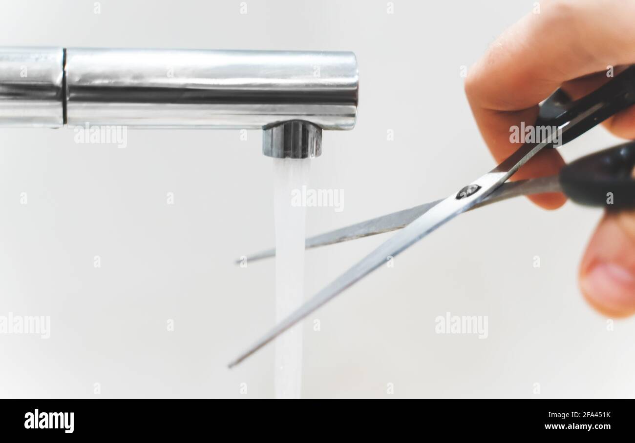 Cutting water with scissors. The concept of useless actions. Stock Photo