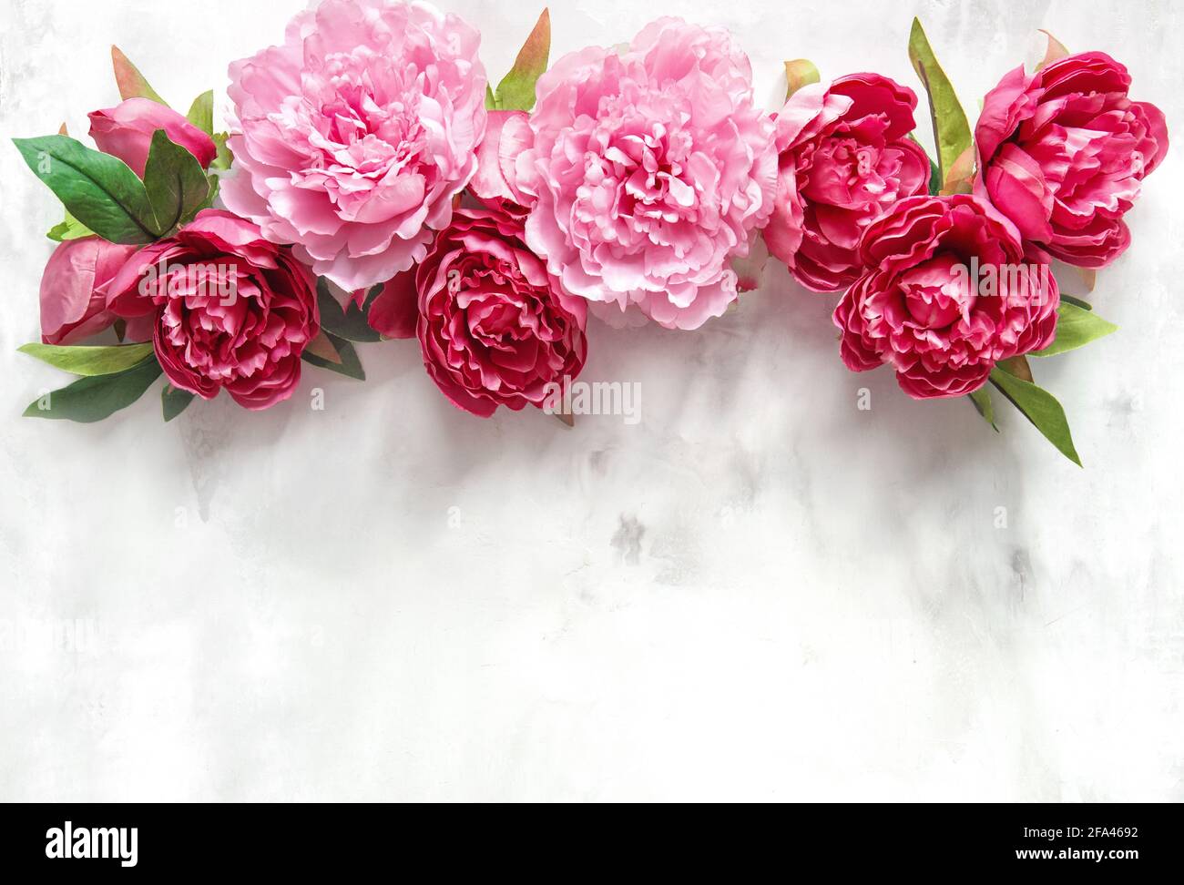 Pink peony flowers bouquet on marble texture. Floral background Stock Photo