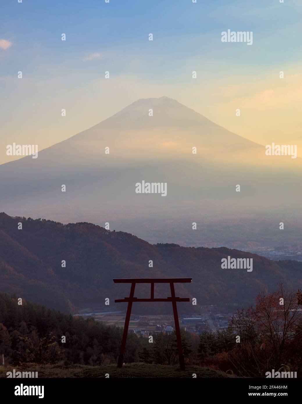 View of the silhouette of a torii gate with Mount Fuji visible in the background at dusk Stock Photo