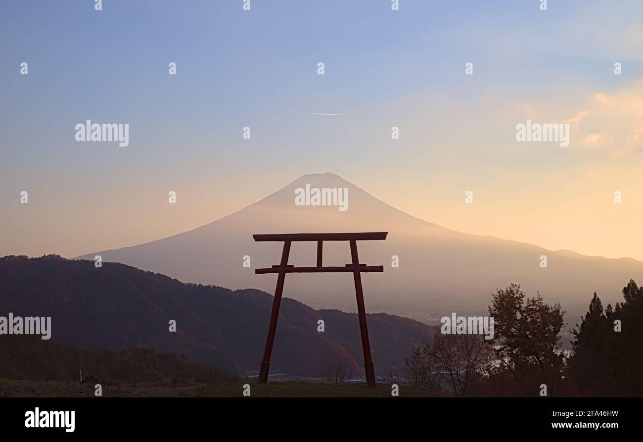 Late afternoon view of the silhouette of a torii gate with Mount Fuji visible in the background Stock Photo