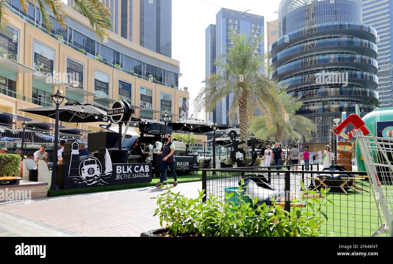 Dubai, UAE - 02.07.2021: View of Dubai Marina modern touristic area with mall, modern buldings, tourists in masks during coronavirus lockdown quaranti Stock Photo