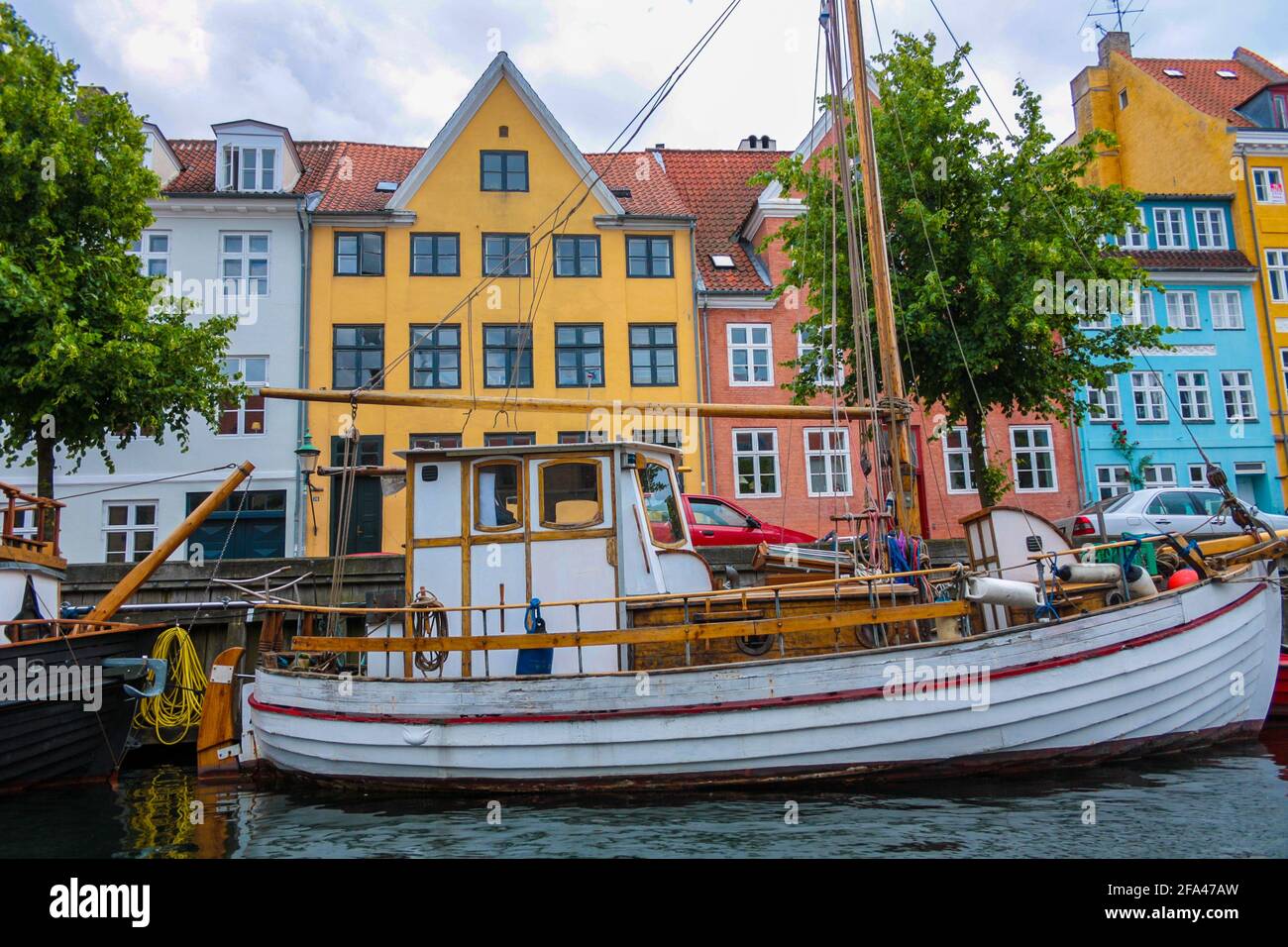 Old wooden barge along a canal in Copenhagen, in the background historic buildings Stock Photo