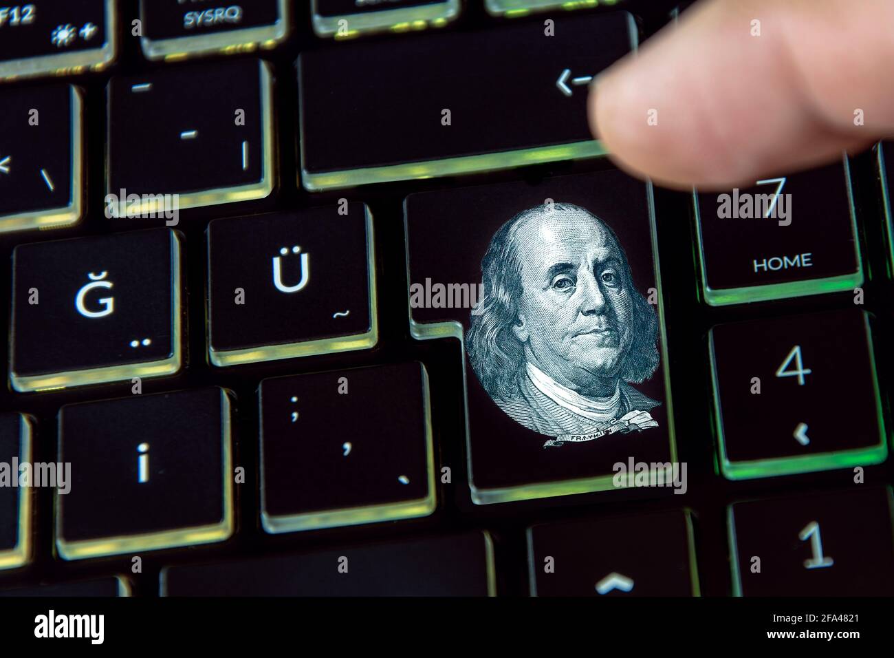 A finger clicks the dollar symbol on the keyboard Stock Photo