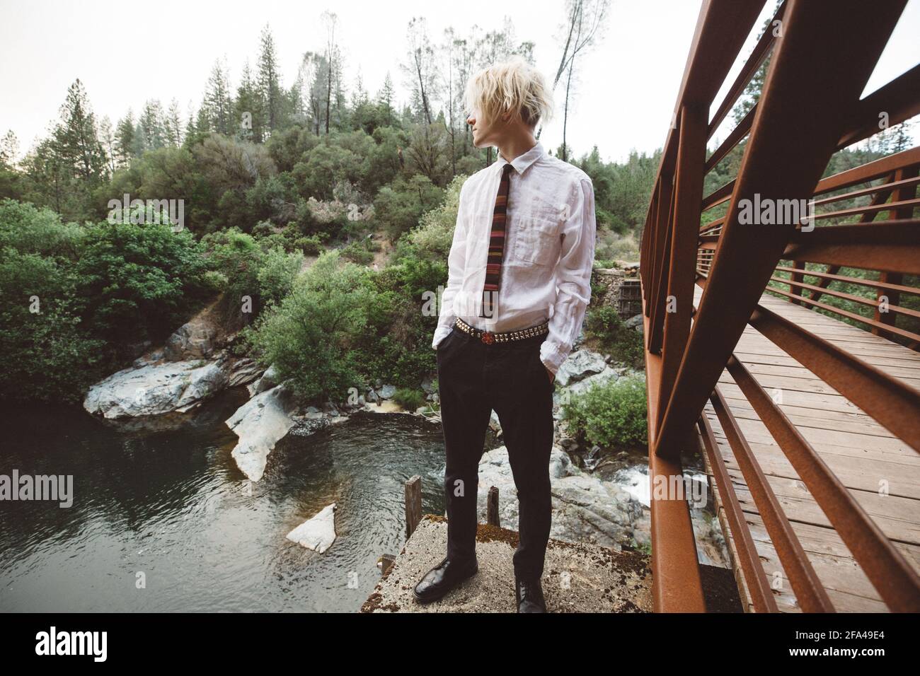 Portrait of Gen Z Teen on a Rust Colored Bridge Hands in Pockets Stock Photo