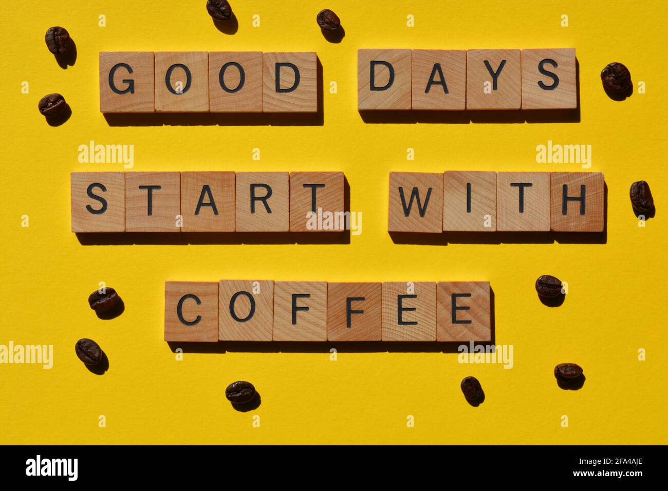 Good Days Start With Coffee, words in wood alphabet letters surrounded by coffee beans on yellow