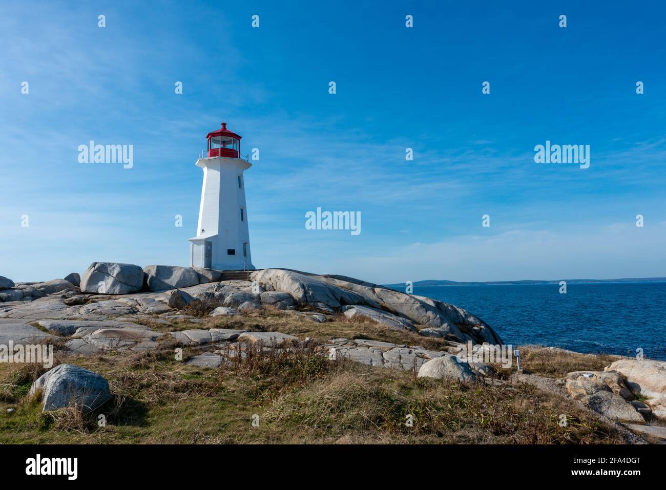 Lighthouse tower made of white concrete hexagonal, six-sided tapering concrete. The structure stands on a rock cliff. Stock Photo