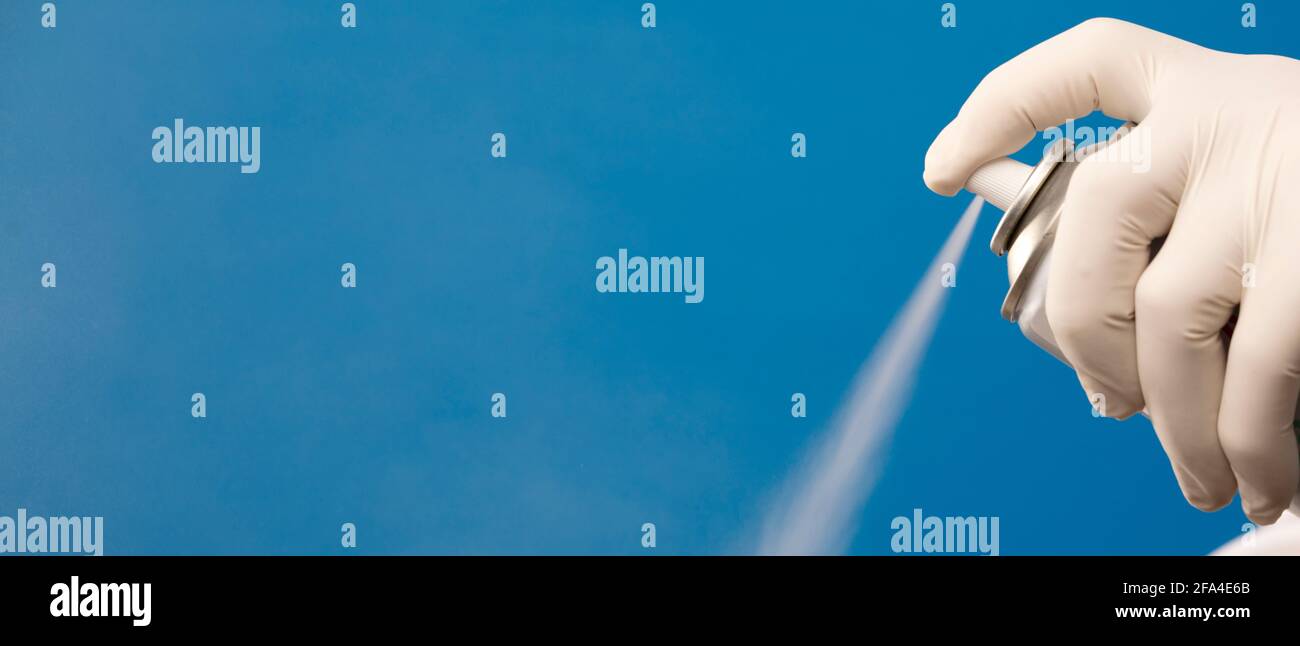 hand with glove and spray in a spray, blue background Stock Photo Alamy