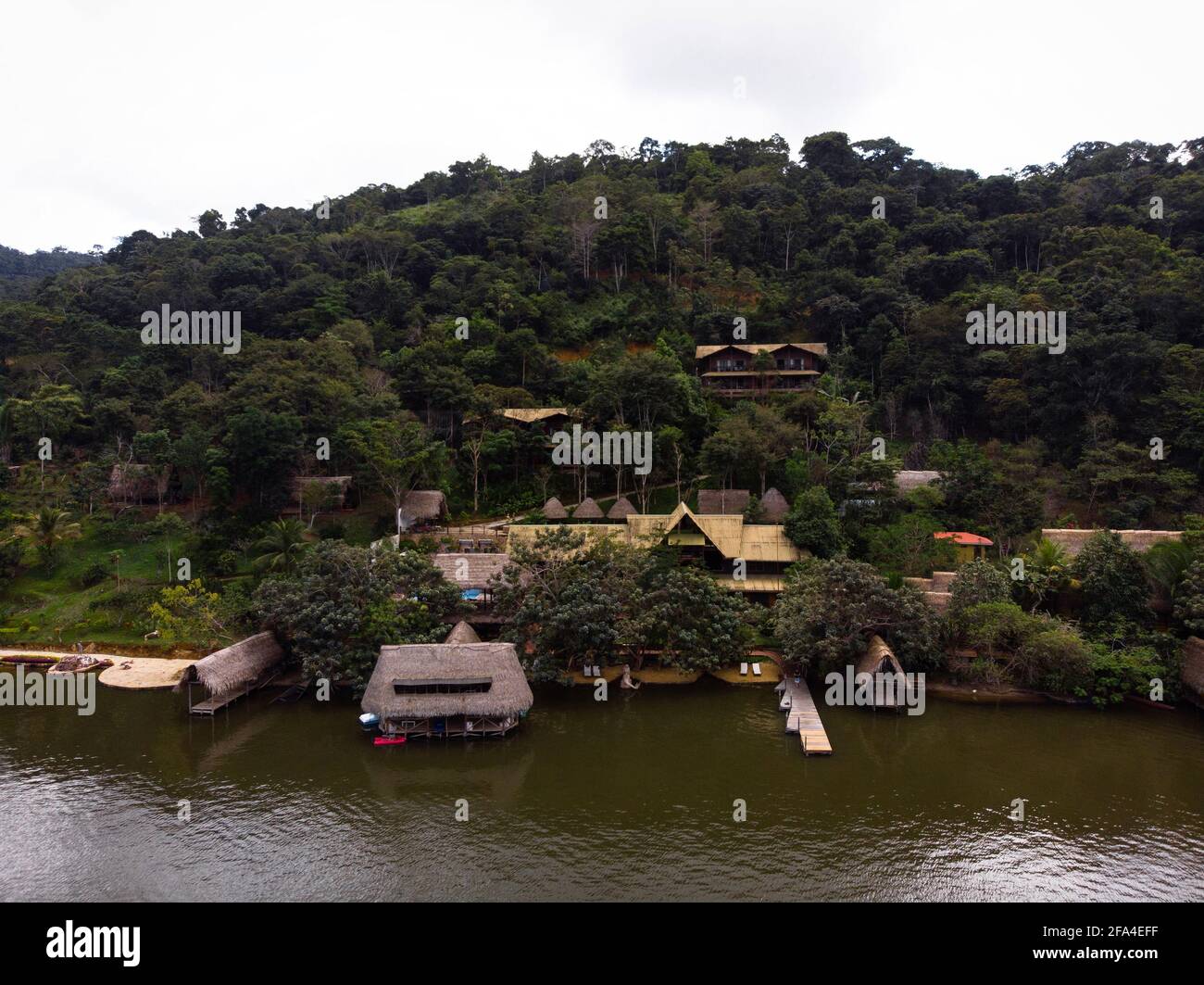 Aerial panorama view of Amazon tropical rainforest exotic lush jungle eco lodge hotel wooden cabin stilt hut at river lake in South America Stock Photo