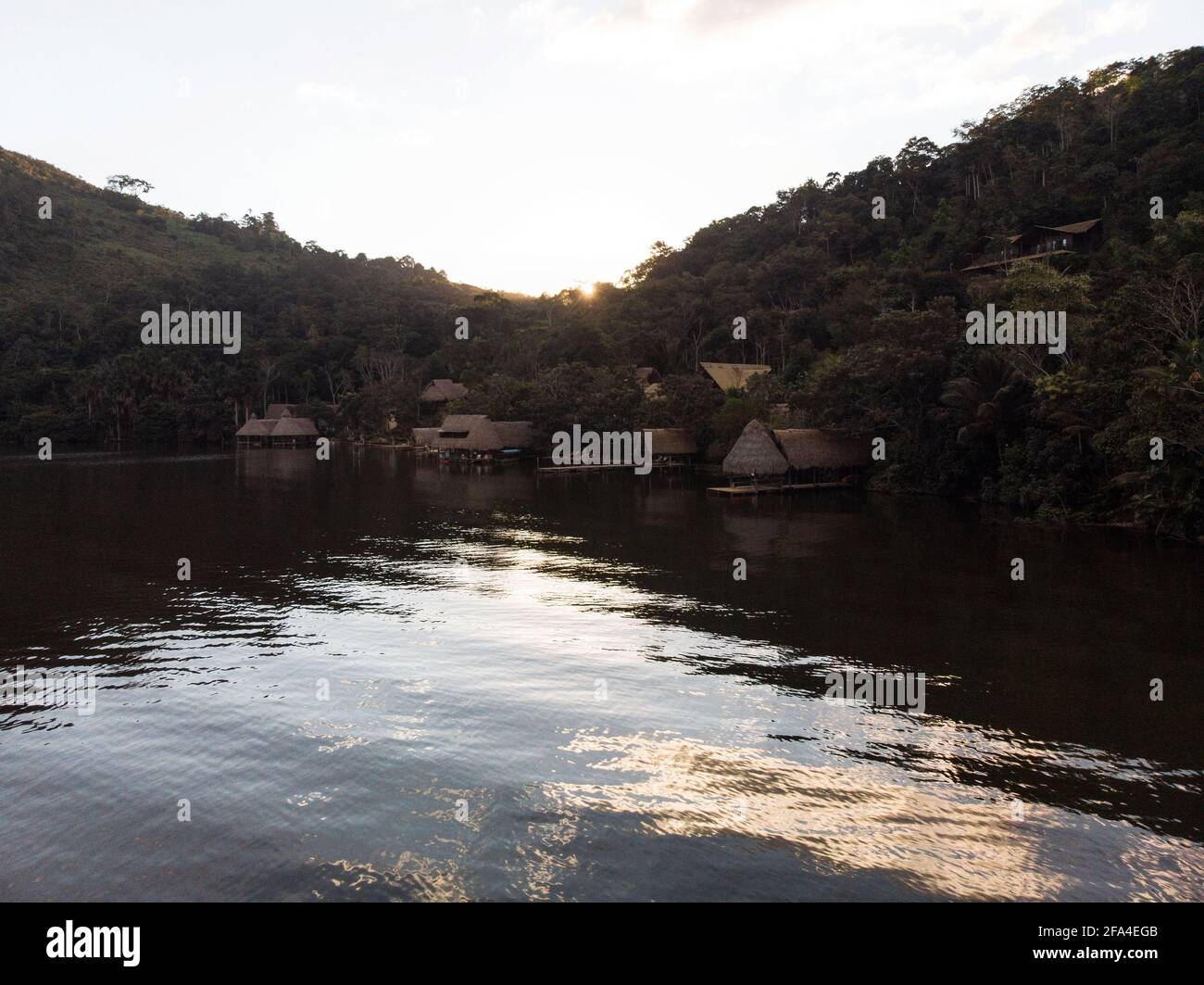 Aerial panorama view of Amazon tropical rainforest exotic lush jungle eco lodge hotel wooden cabin stilt hut at river lake in South America Stock Photo