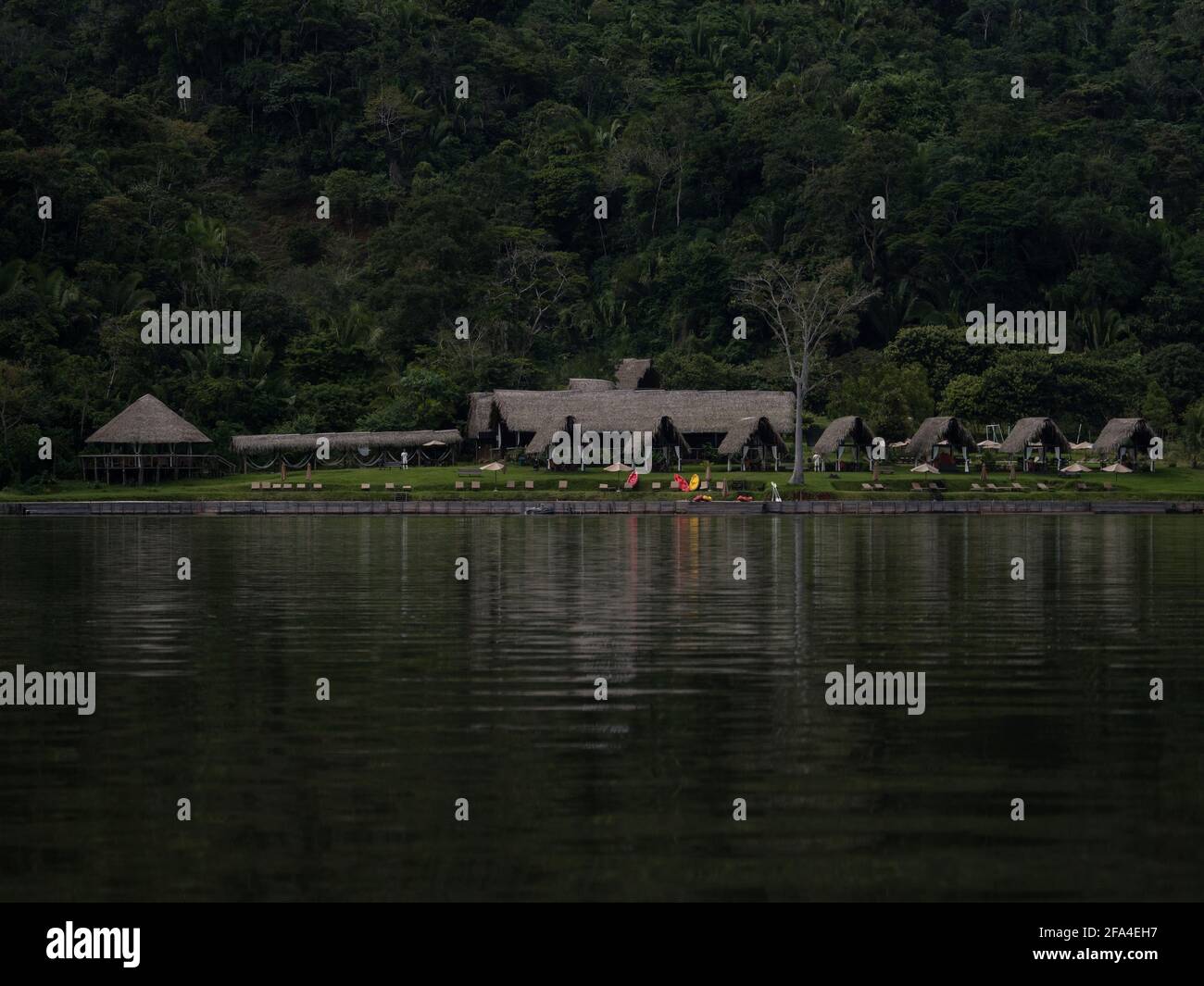 Aerial panorama view of Amazon tropical rainforest exotic lush jungle eco lodge hotel wooden cabin stilt hut at river lake in South America Stock Photo