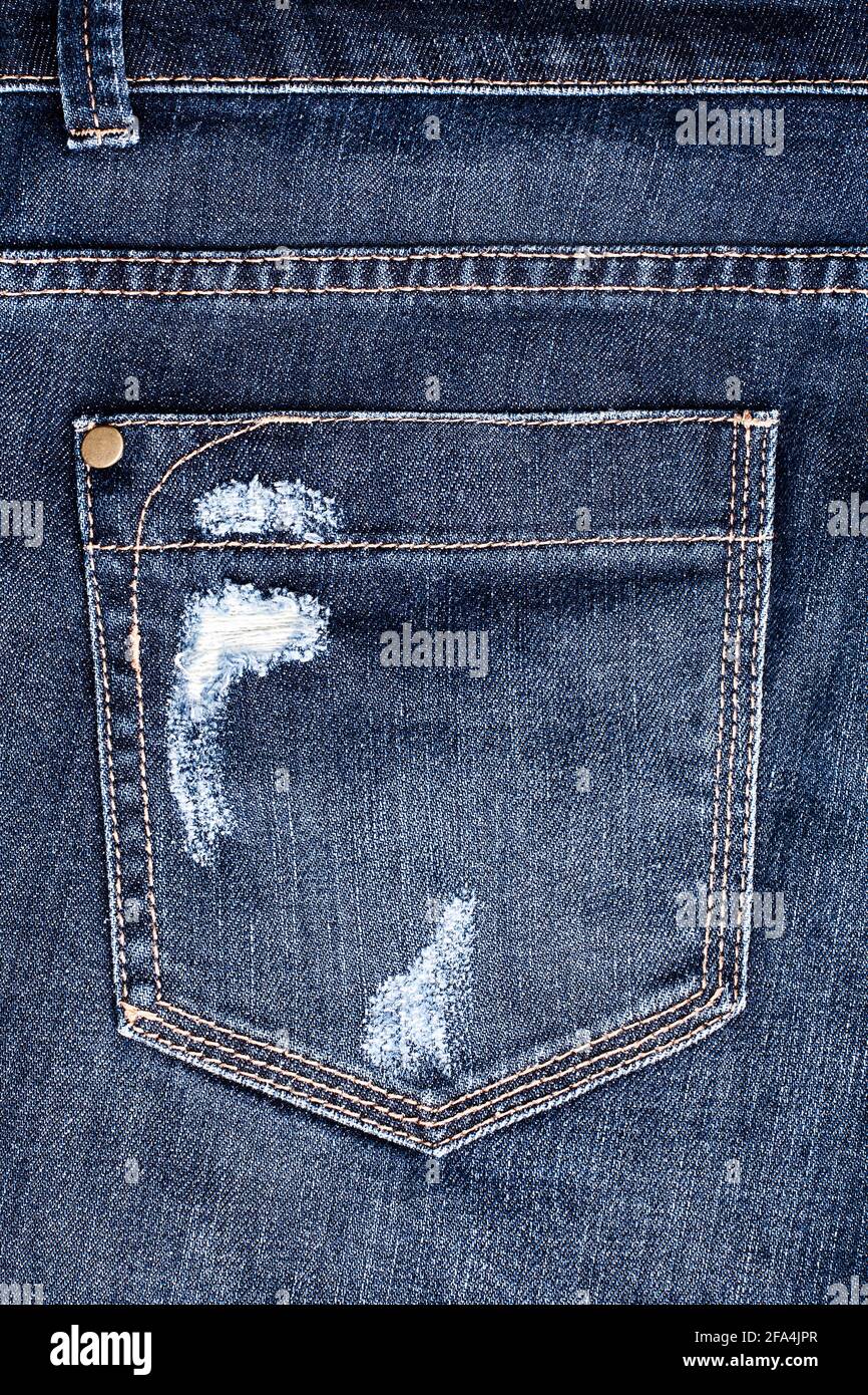 Blue worn jeans pocket close up, ripped jeans pocket background, dark blue damaged denim backdrop, torn jeans pocket pattern, shabby indigo color jean Stock Photo