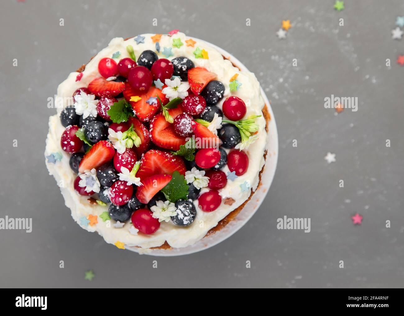 Delicious homemade cake with fresh berries and mascarpone cream on gray background. Top view, copy space Stock Photo
